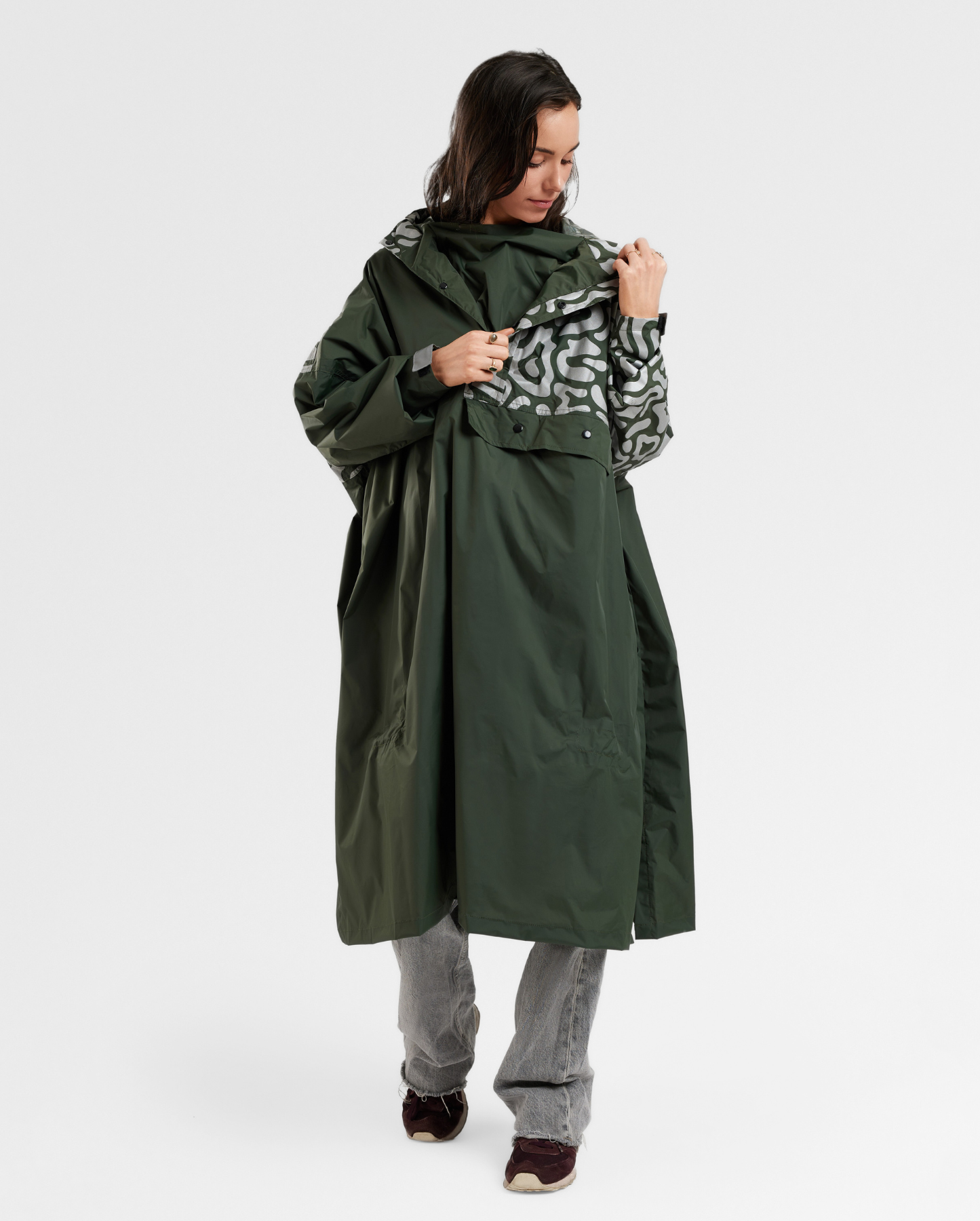 Cycliste urbaine en poncho kaki imperméable, conçu pour les déplacements à vélo sous la pluie en ville