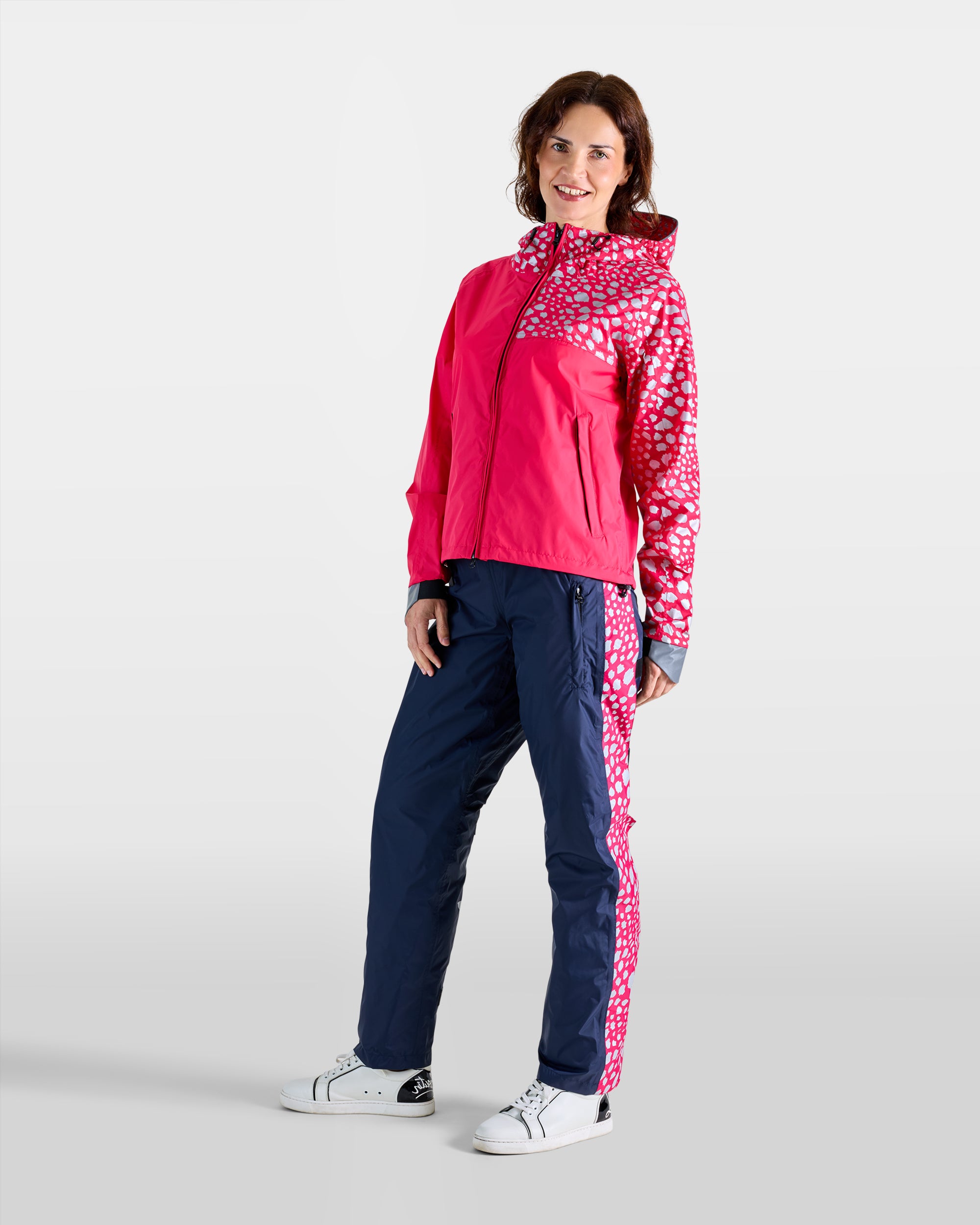 Navy blue and raspberry pink waterproof anorak and rain overtrousers set with cheetah patterns on a woman