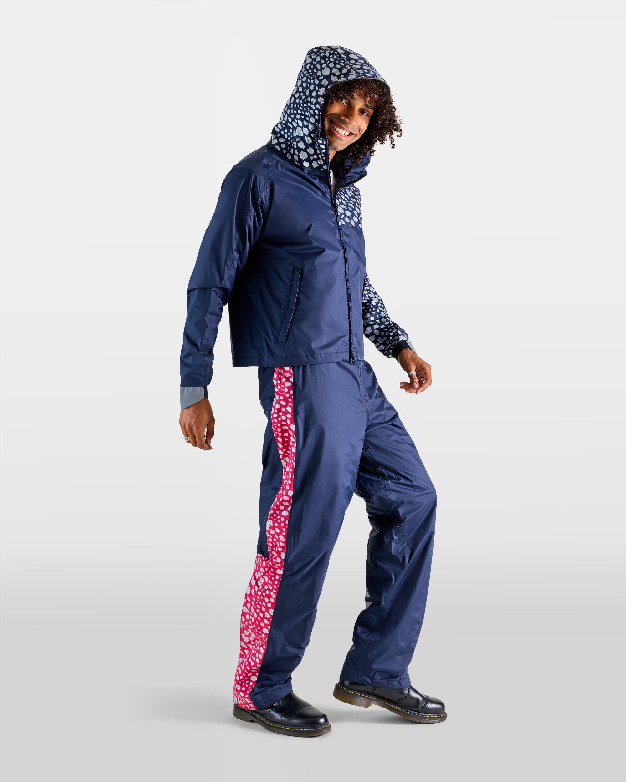Navy blue and pink rain anorak and overtrousers set with cheetah patterns on a man