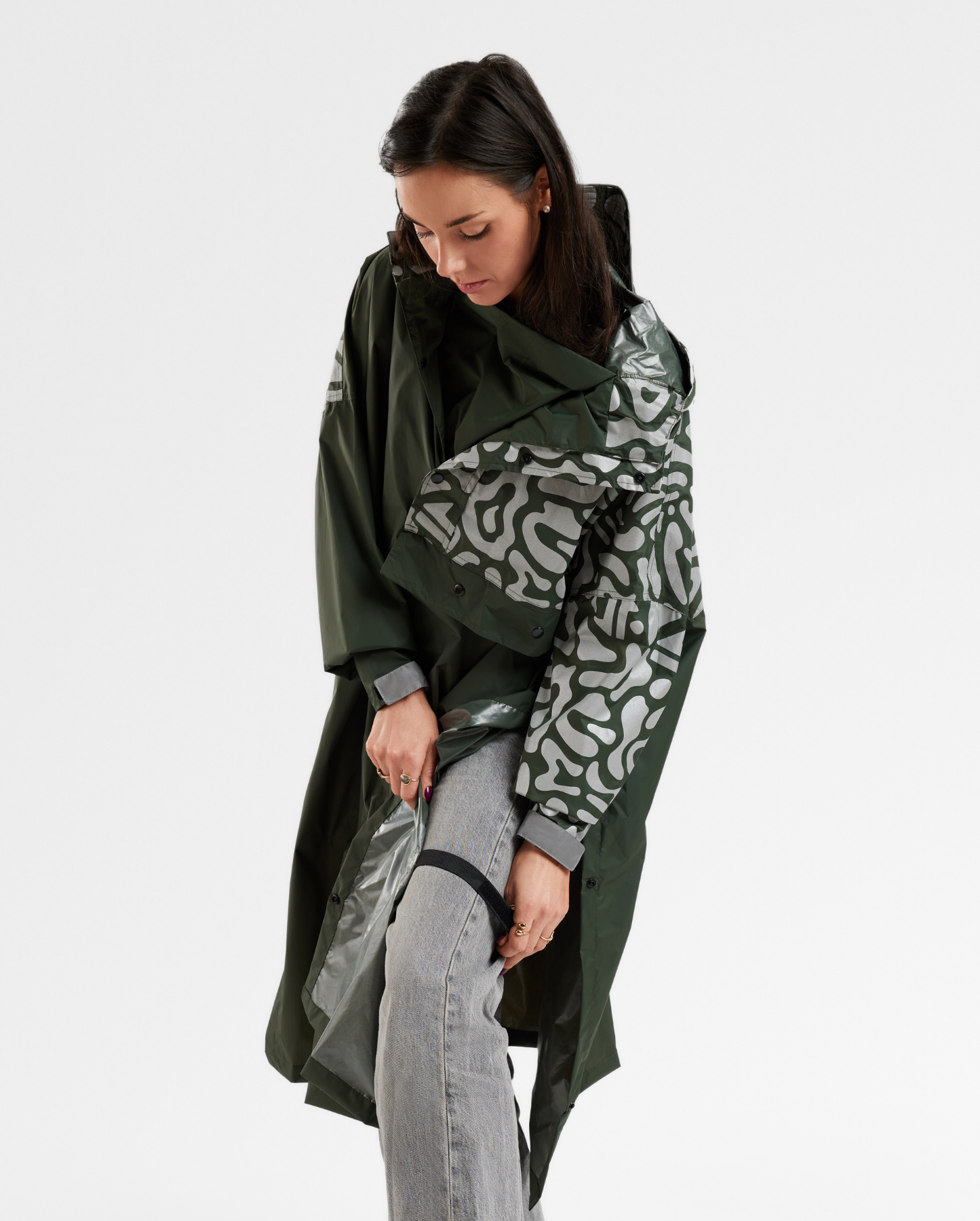 Système d’attache du poncho vélo kaki au niveau des jambes, assurant confort et maintien pendant le pédalage.