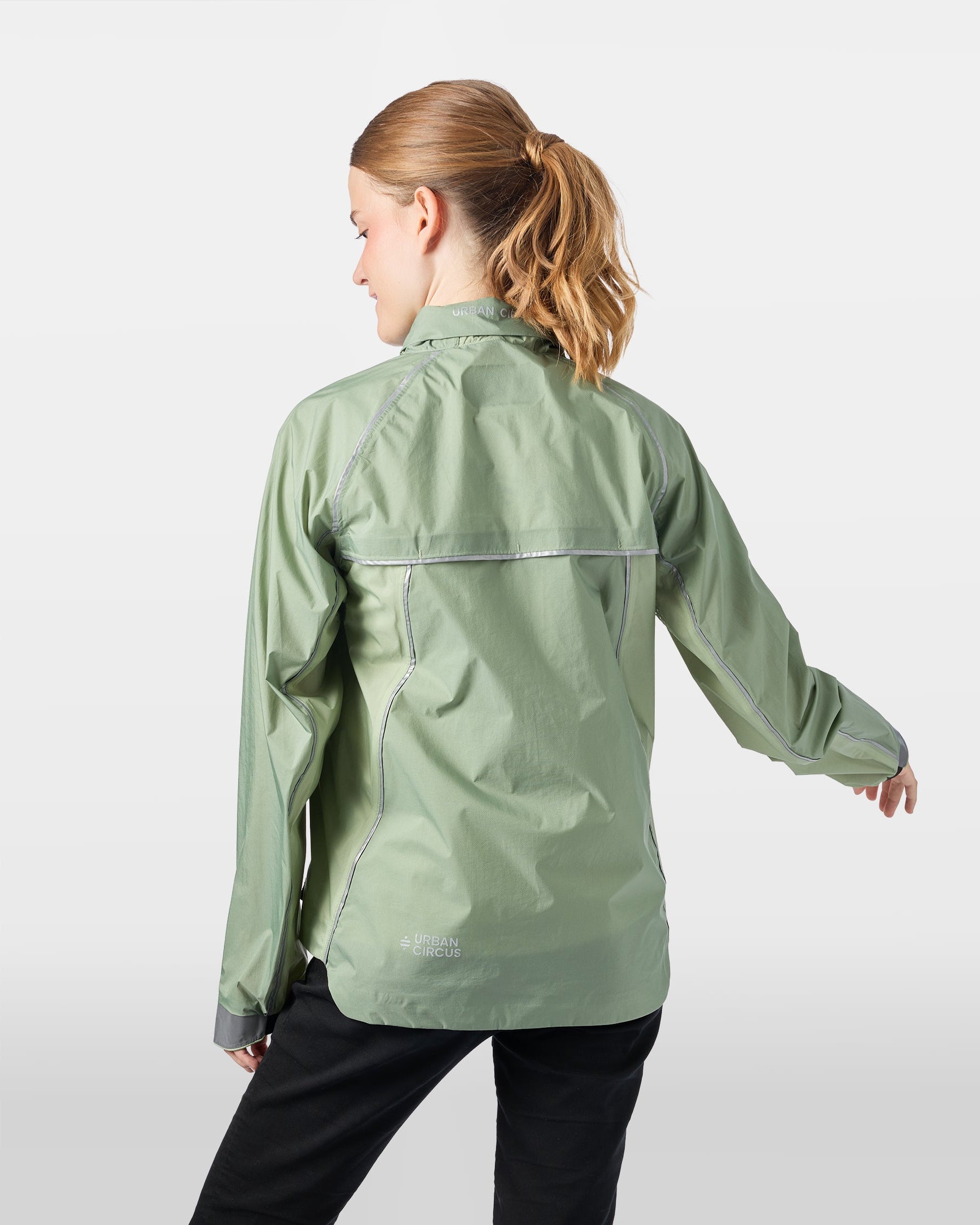 Ultraleichte, atmungsaktive Jacke für Outdoor-Aktivitäten in Salbeigrün an einer Frau von hinten, Kapuze im Kragen verstaut