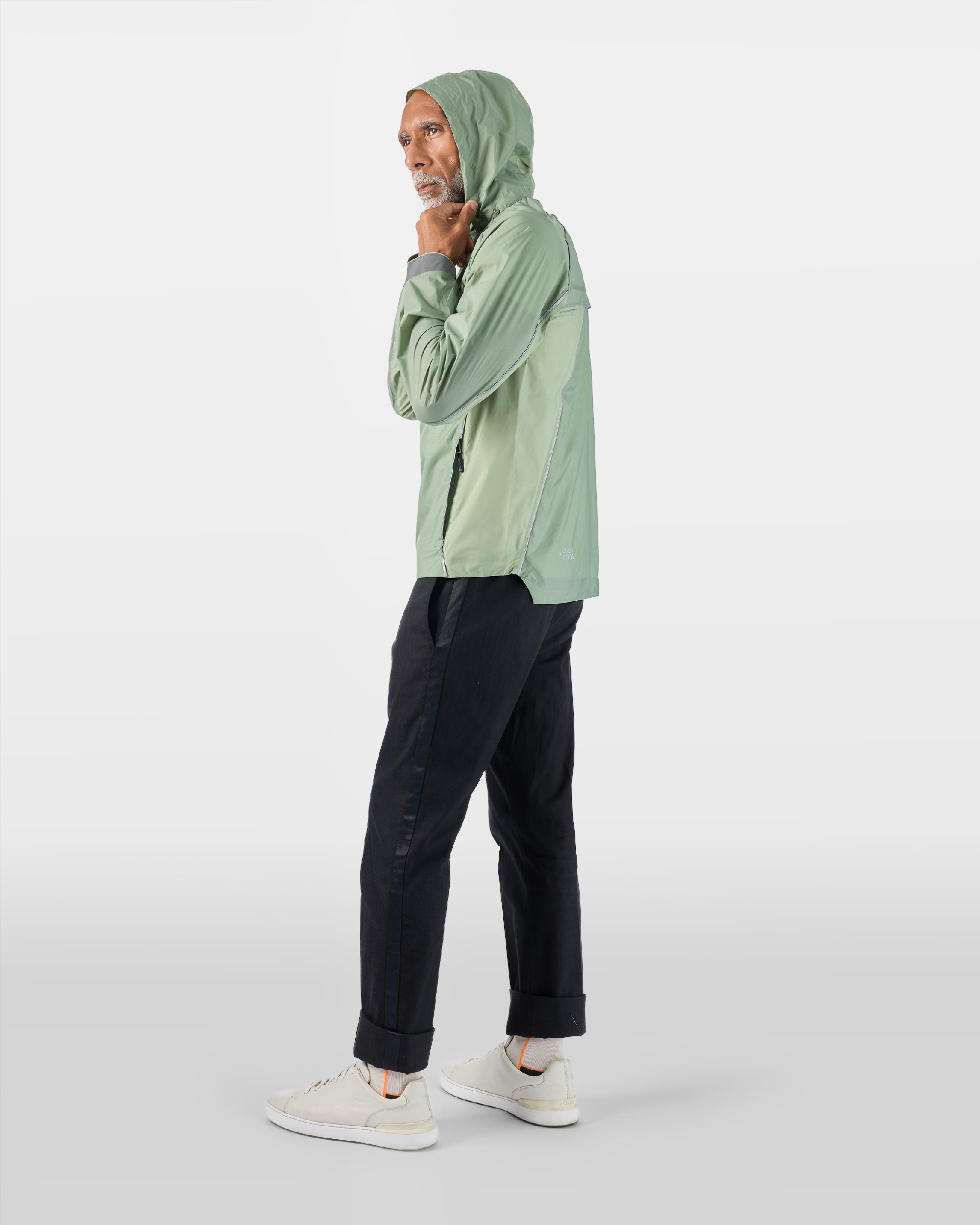 Ultraleichte, atmungsaktive Jacke mit wasserdichter Kapuze in Salbeigrün an einem Mann von hinten