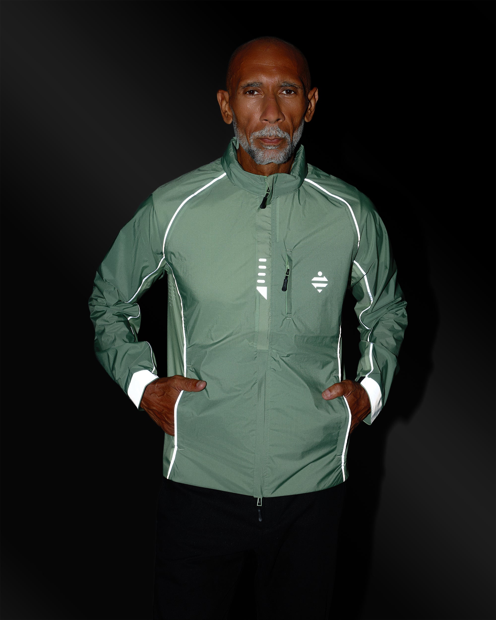 Leichte, atmungsaktive Sportjacke in Salbeigrün mit reflektierenden Details an einem Mann bei Nacht